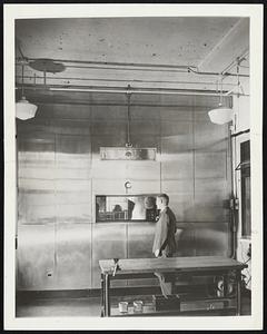 All-Weather Laboratory. Brooklyn, N.Y.-- On the other side of that small window, which is made of six layers of glass, is the Sperry Gyroscope Company's all weather laboratory in which it tests equipment under all kinds of weather conditions. In the picture above a Sperry metallurgist watches the test operations. Men in the laboratory can communicate with him by signaling through the window and talking through a two-way speaking device. Because the laboratory, made of stainless steel, contracts and expands with the chances in temperature, it was suspended from the ceiling.