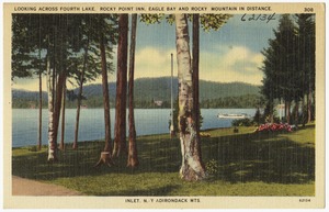 Looking across Fourth Lake, Rocky Point Inn, Eagle Bay and Rocky Mountain in distance. Inlet, N.Y. Adirondack Mts.