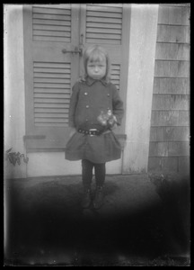 Young girl on porch by shuttered door