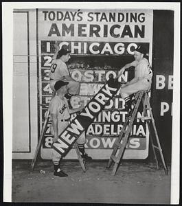 Hanging Up Their Sox-White Sox pitcher Marv Rotblatt (left) and Second Baseman Nellie Fox are helped by Coach Luman Harris as they designate the Pale Hose as the league leaders. Don't look now, boys, but there are some Red Sox hanging on the line, too, and very close.
