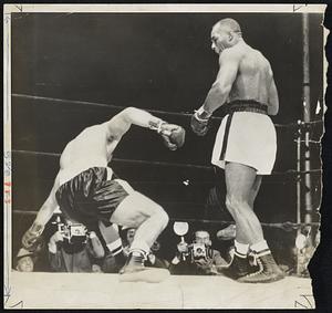 Going Down is Rocky Marciano in first round of heavyweight championship fight as Jersey Joe Walcott stands over him.