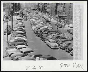 Police Ease Parking Rules - Detroit police eased parking rules here to assist shoppers and workers in the downtown area. With the Detroit Street Railway strike in its 21st day present parking facilities proved totally inadequate. Cars may be seen off to the distance parking in the center of Woodward Avenue. Two cars at the extreme left are parked on the sidewalk.