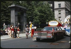 Car with a sign for La Unica Muebleria Hispana on top, Reina float behind, Festival Puertorriqueño 1976, Granary Burying Ground to the left