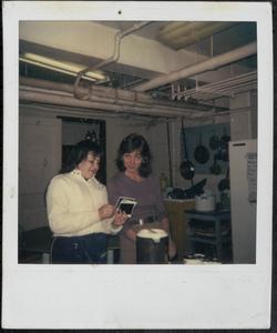 Two women looking at Polaroid photos