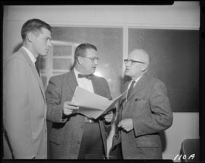 Three men looking at folder
