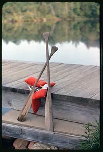 Oars and life vest on dock