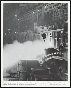 The jet tapping process shown here uses a rocket-like explosive charge to blast through a special clay plug at the rear of the open hearth furnace, thus permitting the hot steel to flow into an awaiting ladle.