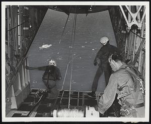 Data Package is taken from deck of ship by ingenious airborne snatch, is reeled into rescue-and-recovery plane.