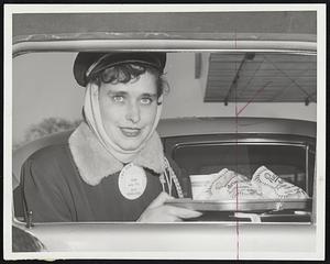 Tough on Car Hops, the bitter bite of winter causes Lorraine Gallant of Boston to bundle up and wrap her ears in a scarf as she served drive-in customers.