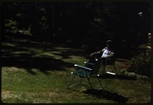 A man sitting on a lawn chair, an empty chair next to him