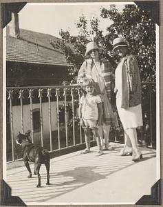 Two unidentified women and child to the right of a Boston terrier