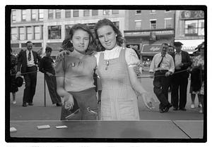 Two girls holding jacks, wearing medals
