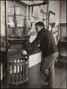 Ralph Ratcliffe of Saxonville, Mass. scanning a model of the frigate "Constitution" constructed by Lt. Colonel W.F. Spicer, U.S.M.C.