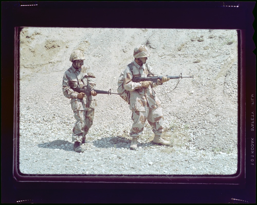 Cemel- 2 men in camouflage fatigues by trees, side view