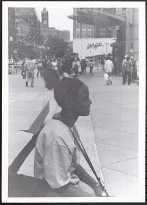Young woman sitting with a camera on Boylston Street