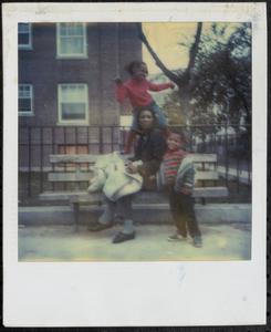 Woman posing on a bench with two children