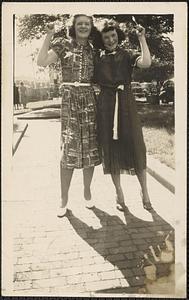 Two women stand with their arm around each other