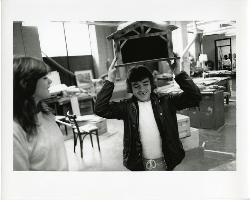 Teenager holding a small wooden construction above their head