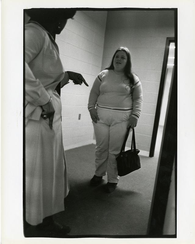 Teacher addressing a student in a hallway