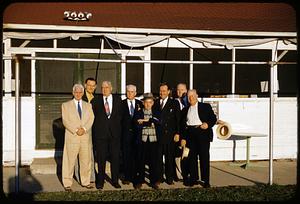 Group of men posing outside building