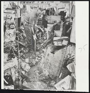 In Papillion, Neb., a drugstore owner (left), almost obscured by wreckage piled up in flooding.