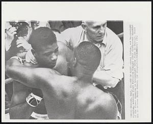 End of Fight--Sonny Liston, new heavyweight champion, embraces Floyd Patterson tonight after first-round knockout of the former champion in heavyweight title fight in Chicago. Third man is referee Frank Sikora.