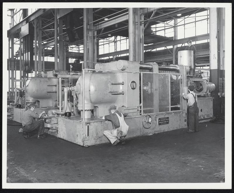 (Shop Assembly Photos of Two 1200-H-60B Machines) One of the country's largest injection molder of plastics-The Ideal Novelty and Toy Company of Long Island, New York, recently purchased two of the biggest plastics injection molding machines ever built, which, upon installation will mold parts up to 200 ounces in weight. These machines are being built by The Hydraulic Press Mfg. Company. A. M. Katz, General Manager of Ideal, indicated these new machines are being purchased to handle sub-contract work on refrigerator parts, telivision windows, and other big moldings including defense orders. These two huge machines, shown in the photo above, are now under test in H-P-M's Mount Gilead, Ohio, plant and are scheduled for shipment to Ideal January 30. These injection molding machines have a maximum die space of 48" x 60", 60" daylight and 1200 ton mold clamp with 36" stroke. Each machine weighs 112,000 pounds. Their extremely large "shot" capacity will permit them to handle all large molds now in production and even bigger molds now being designed. Mr. Katz indicated that open time is available on these giant machines for additional custom molding work.