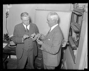 Perlin L. Charter, assistant chemist in the Worcester department of public health (left) and Charles J. Van Amburgh, expert on firearms and explosives, examine unidentified material probably related to Thayer house explosion