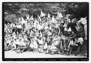 Boys holding model sailboats