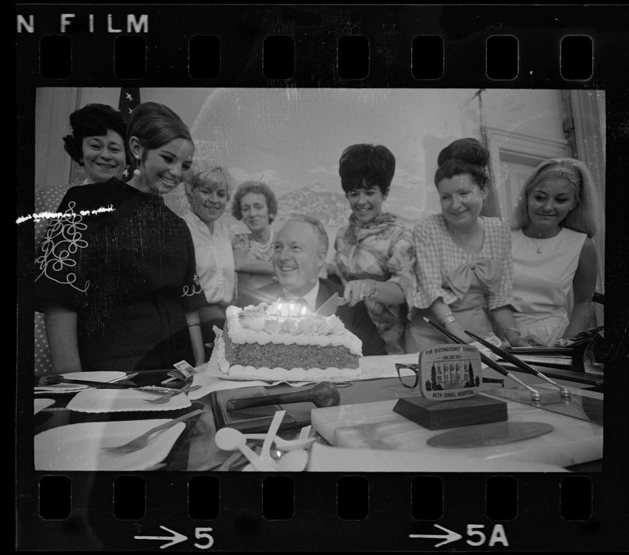 Mayor Collins, who celebrated his 48th birthday yesterday, gets assistance from office aides in blowing out candles on cake