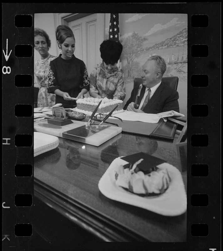 Mayor Collins, who celebrated his 48th birthday yesterday, gets assistance from office aides in blowing out candles on cake