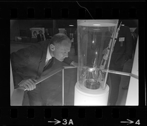 Astronaut Edwin E. Aldrin views a piece of moon rock