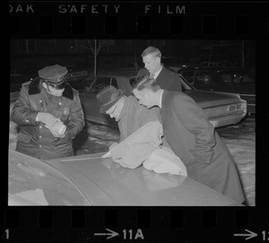 Men examining the trunk of a car