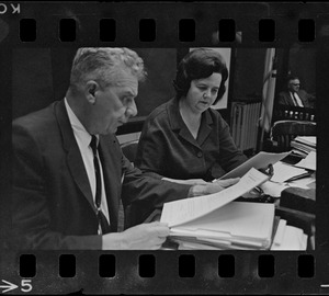 Supt. Of Boston Schools William H. Ohrenberger, left, looks over a subpoena served him along with Mrs. Louise Day Hicks, chairman, right, and all other School Committee members by a Federal Marshall last night