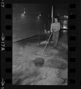 Man sweeping debris at site of school fire