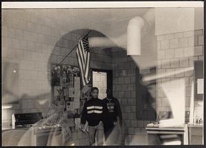 Young men walking in front of a bulletin board