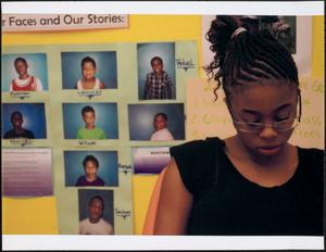 Girl with glasses in front of photo collage