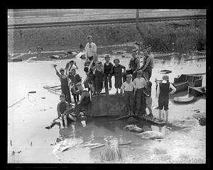 A group of boys posing by debris, possibly parts of an automobile