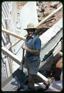 Man with shovel standing at construction or excavation area
