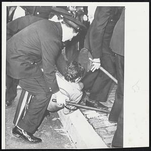Woman Demonstrator is collared by police on curbstone near United Nations headquarters in New York as rioting marked opening of General Assembly.