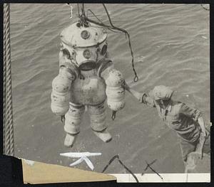 Down to the Sea in Slips--This weird looking object, a cross between a fir closs cooker and a bouquet of balloon tires, is a new deep sea diving device shown in operation at Genoa, Italy, in the Universal Newsreel. It is designed for treasure salvaging and on the day this picture was made the man in the machine was prowling [t]he ocean floor in search of a rich copper cargo sunk [du]ring the World War.