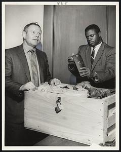 Portion of Hashish seized in $1.2 million haul, is displayed by Asst. U.S. Atty. Willie Davis, right, as Clifton L. Mentzer, a Treasury customs agent, describes the Andover raid.