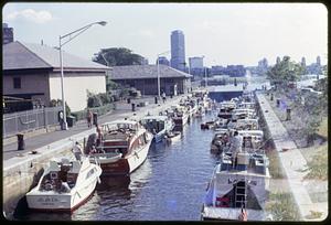 Two rows of boats in a waterway, the Prudential Tower in the background