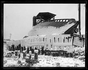 Ice covered boat on its side out of the water, probably after a storm