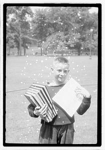 A boy holding a stack of books