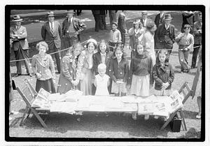 A group of girls behind a collection of books