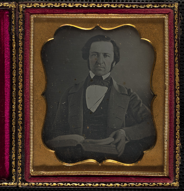 Portrait of man with book on lap