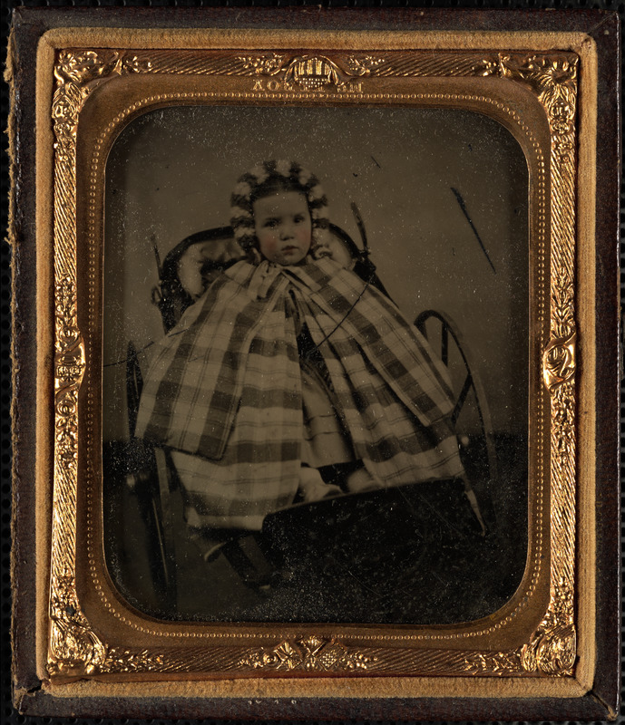 Portrait of child in miniature carriage