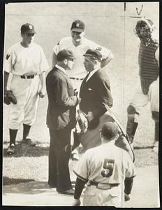 Umpire Disputes Umpire's Decision, and that really is something for the baseball book, because here is one case where the umpire can't kick out a man for arguing. The strange incident took place at Washington after Umpire-in-Chief John Quinn (right), had ruled that Jake Early, Washington catcher, had interfered with Bob Kennedy of the Chicago White Sox, the batter. Umpire Bill McGowan, working at third base, differed with Quin, this being the photographic evidence. Ken Chase, Washington pitcher, is at the left, while First-baseman Zeke Bonura is laughing at his argument. With his back to the camera, but undoubtedly enjoying the act, is Jimmy Dykes, Chicago manager, who has had plenty of arguments with umpires.