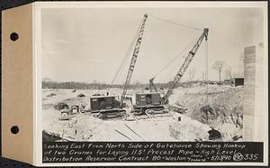 Contract No. 80, High Level Distribution Reservoir, Weston, looking east from north side of gatehouse showing hookup of two cranes for laying 11.5 feet precast pipe, high level distribution reservoir, Weston, Mass., May 13, 1940